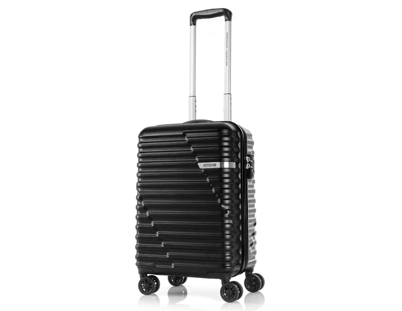 A sleek black suitcase with a ribbed exterior design and a retractable handle stands upright on four spinner wheels. The bag features a TSA lock, making it an ideal travel companion for journeys.