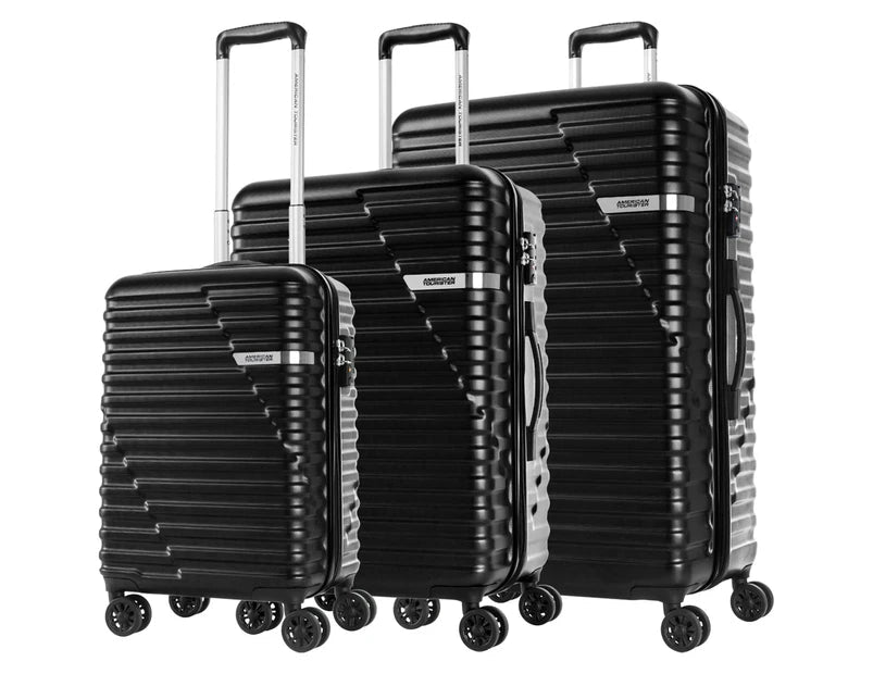 Three sleek black hardshell suitcases are displayed together, showcasing a modern ribbed design. Each suitcase features an extendable handle and multiple wheels for easy maneuverability, making them ideal for travel.